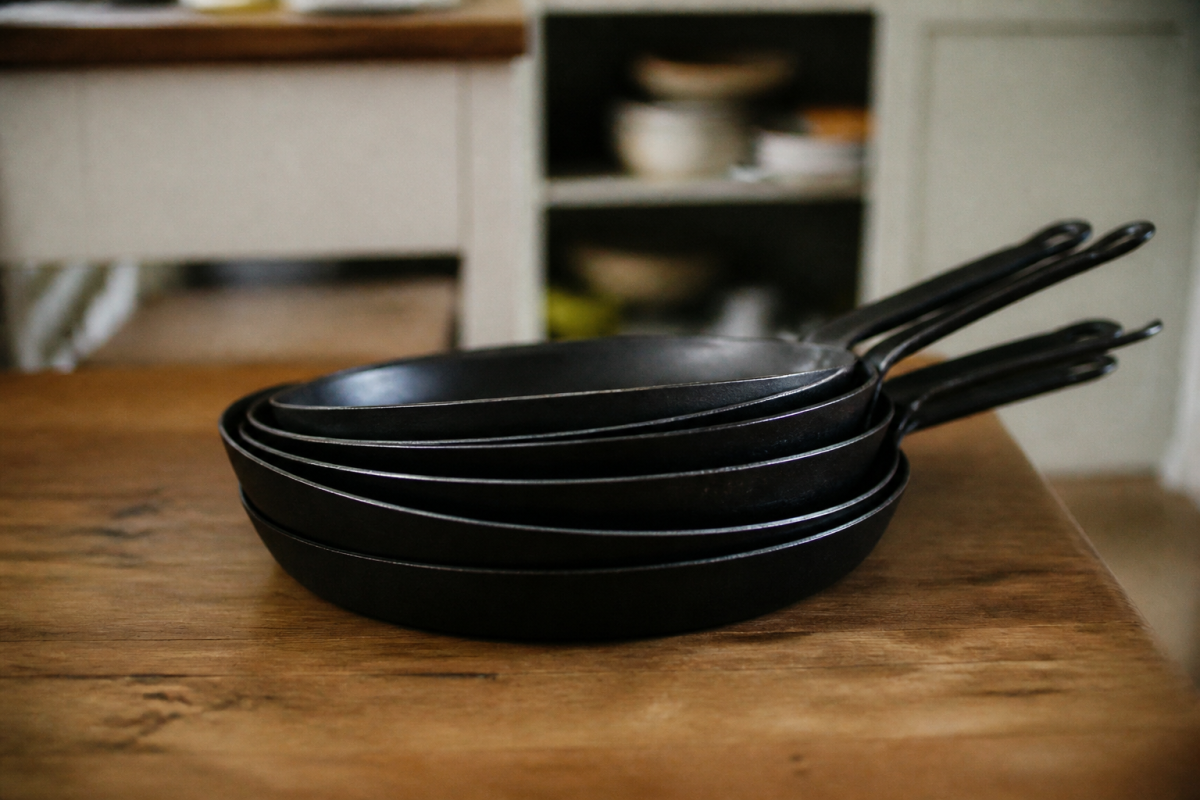 Poeles noires en metal empilees sur table