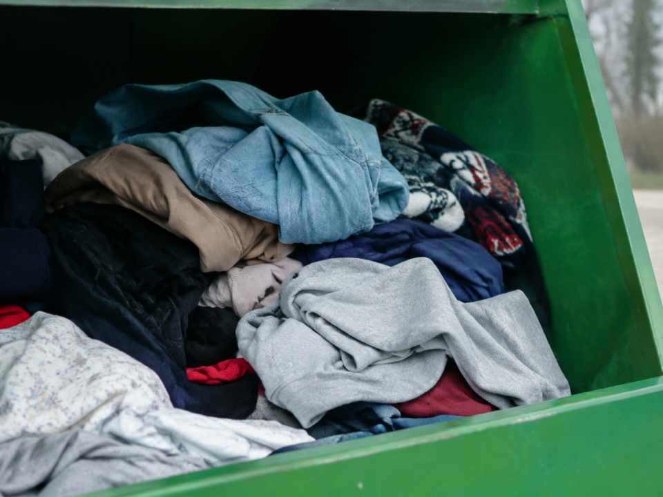 Vetements empiles dans bac de collecte textile